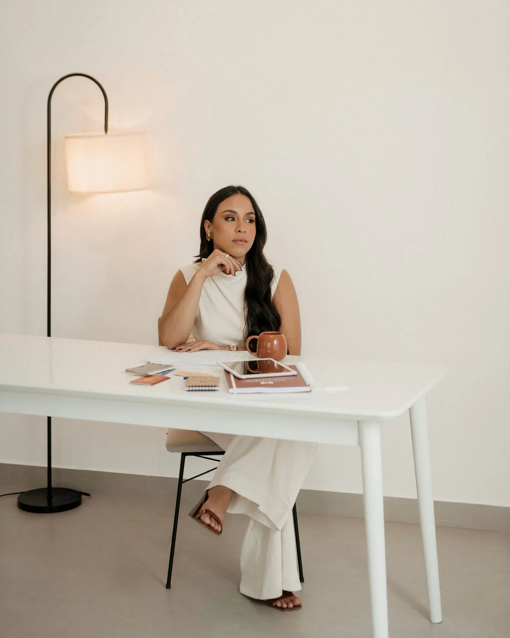 Amanda Mendes sentada à mesa de trabalho, em ambiente profissional